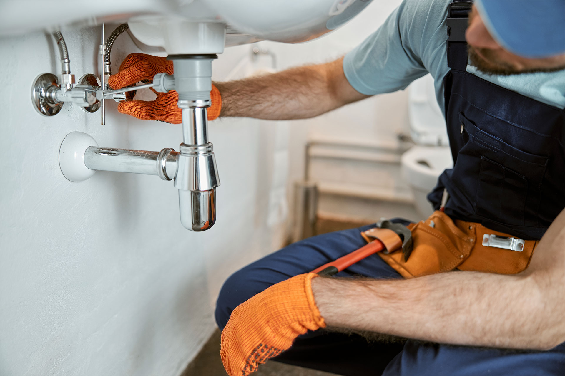 plumber working under a bathroom sink