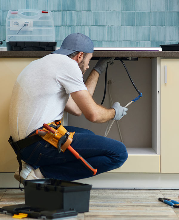 plumber working under a kitchen sink