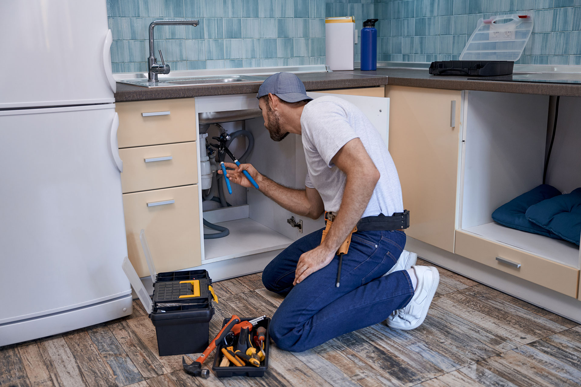 plumber working under a kitchen sink